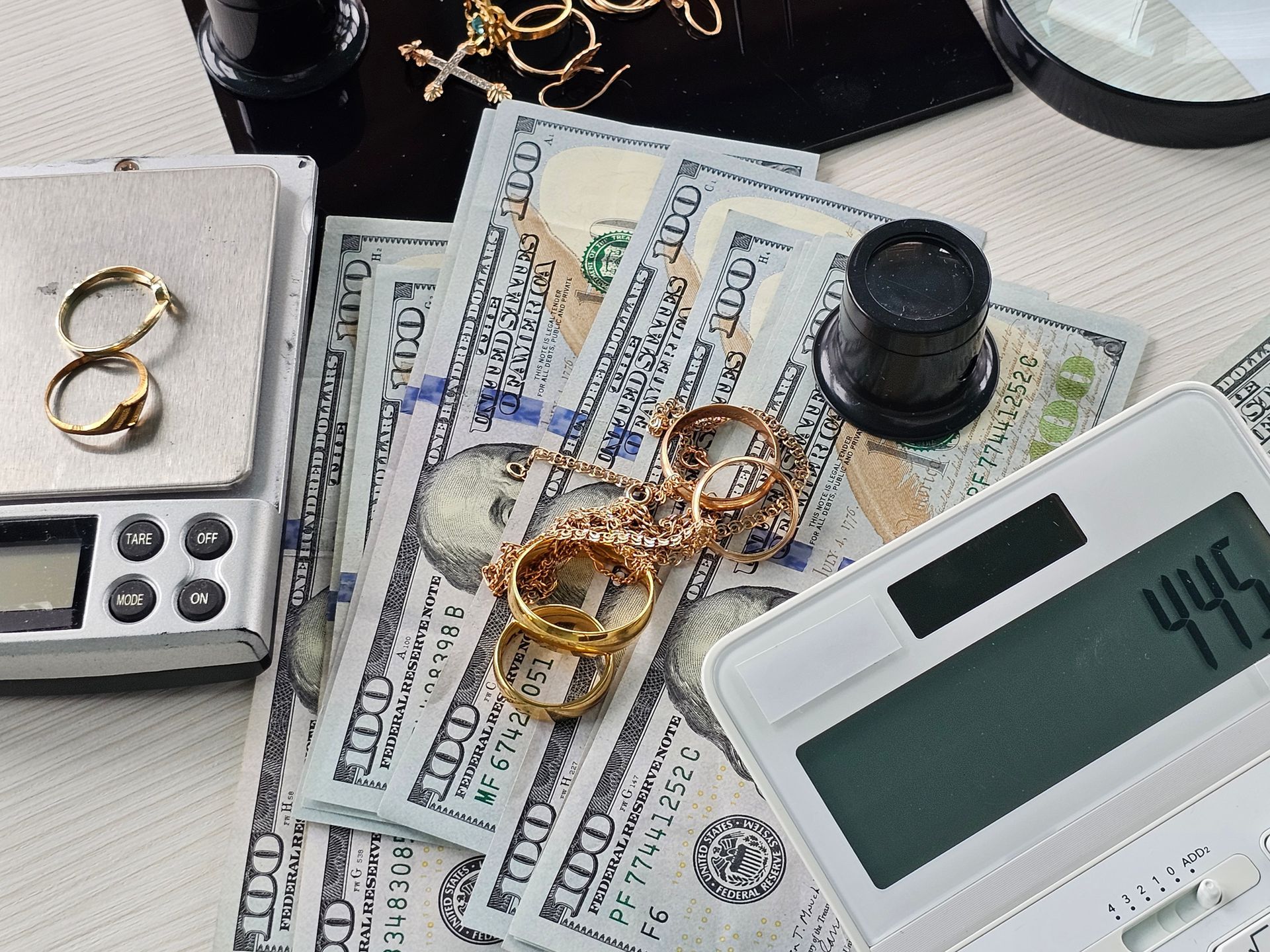 Jewelry and cash laid out on a table during assessment and valuation process concept