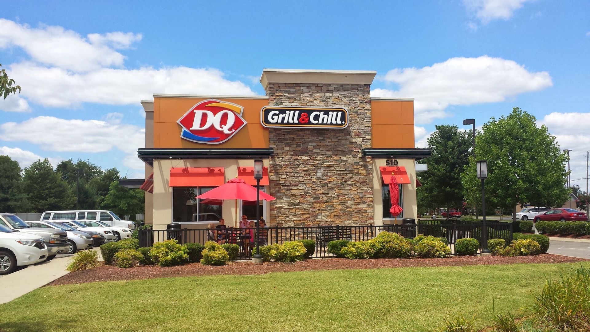 A dq grill and chill restaurant is located in a parking lot.