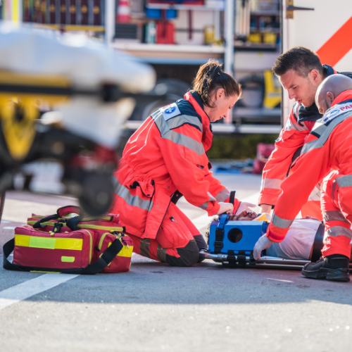 A group of paramedics are helping a person on the ground