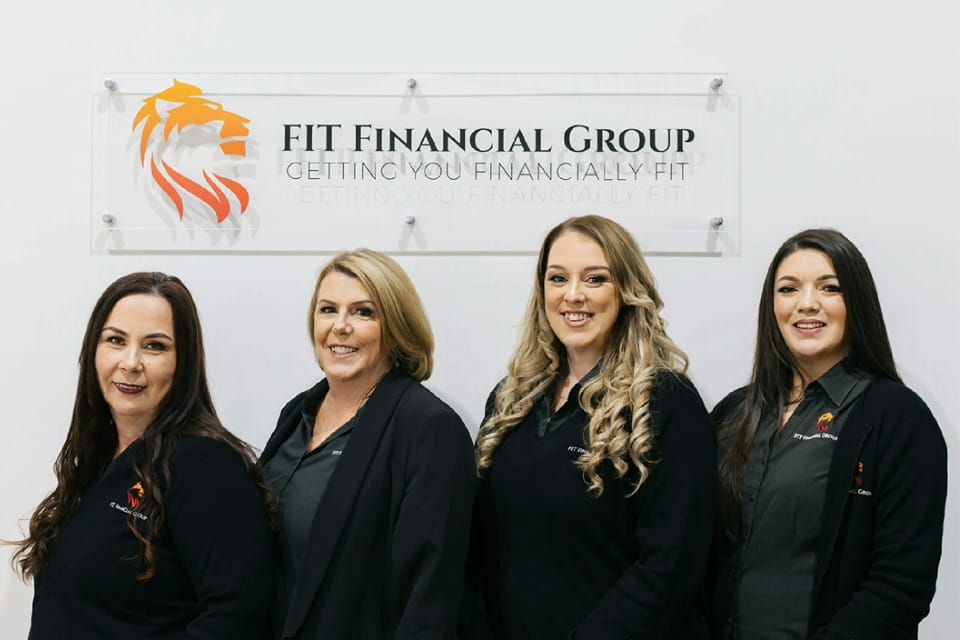 Four Women in Black Shirts in Front of a Sign — Fit Financial Group in Leumeah, NSW