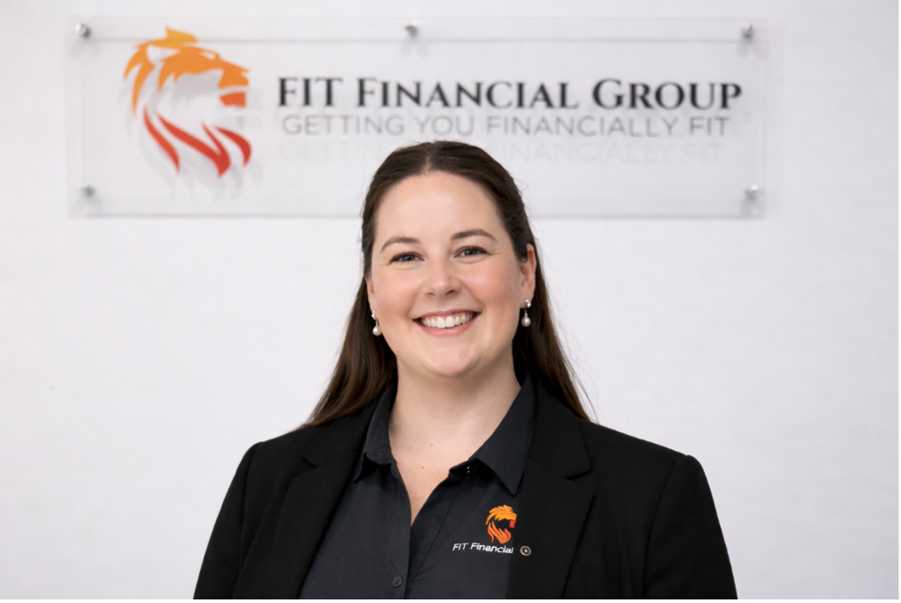 Woman smiling in front of a FIT Financial Group sign featuring a lion logo  — Fit Financial Group in Leumeah, NSW