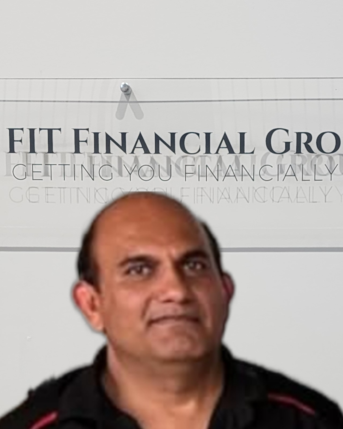 Man smiles below a sign for FIT Financial Group with a lion logo — Fit Financial Group in Leumeah, NSW