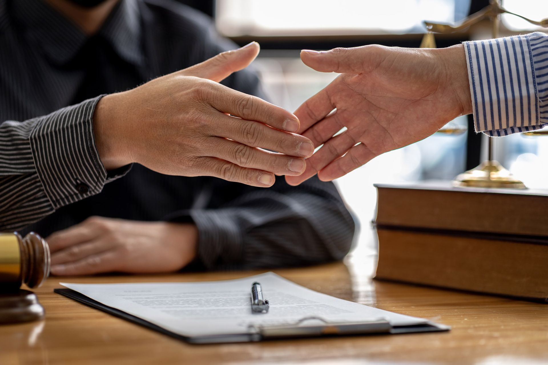 A man is shaking hands with another man while sitting at a table.