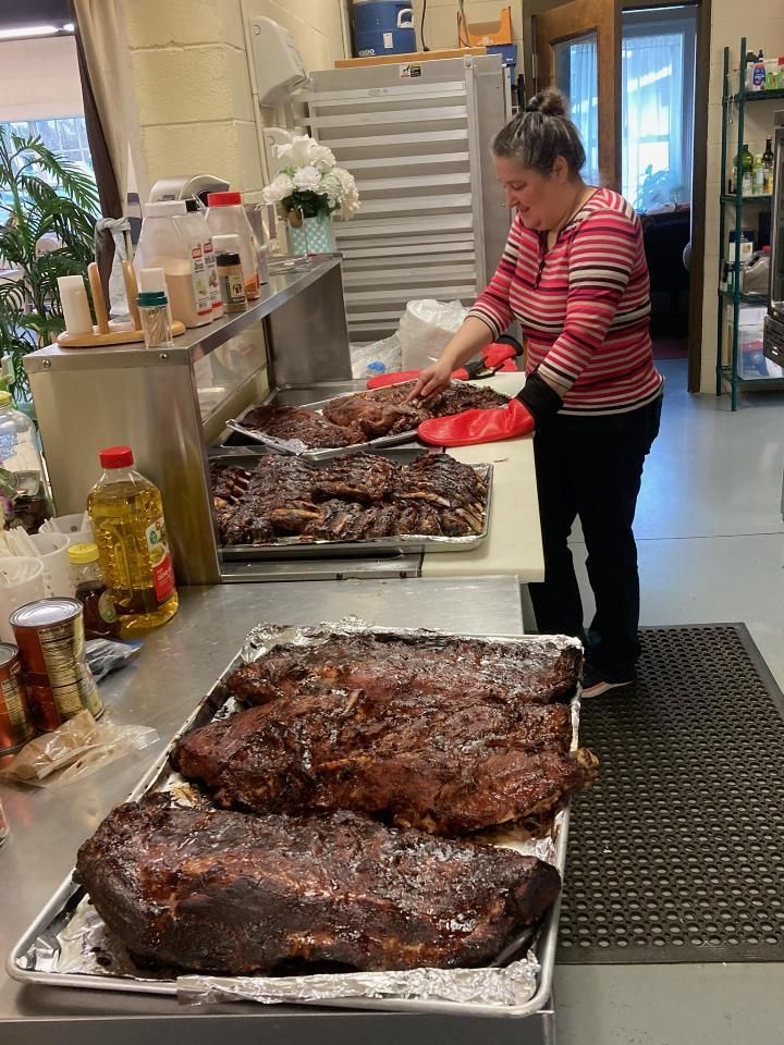 A woman is standing in a kitchen preparing food.