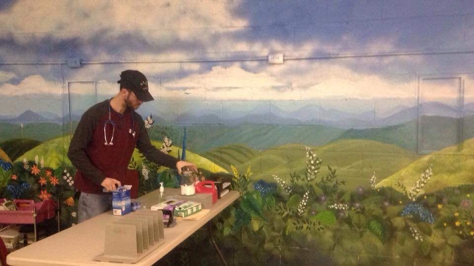 A man is painting a mural on a wall.