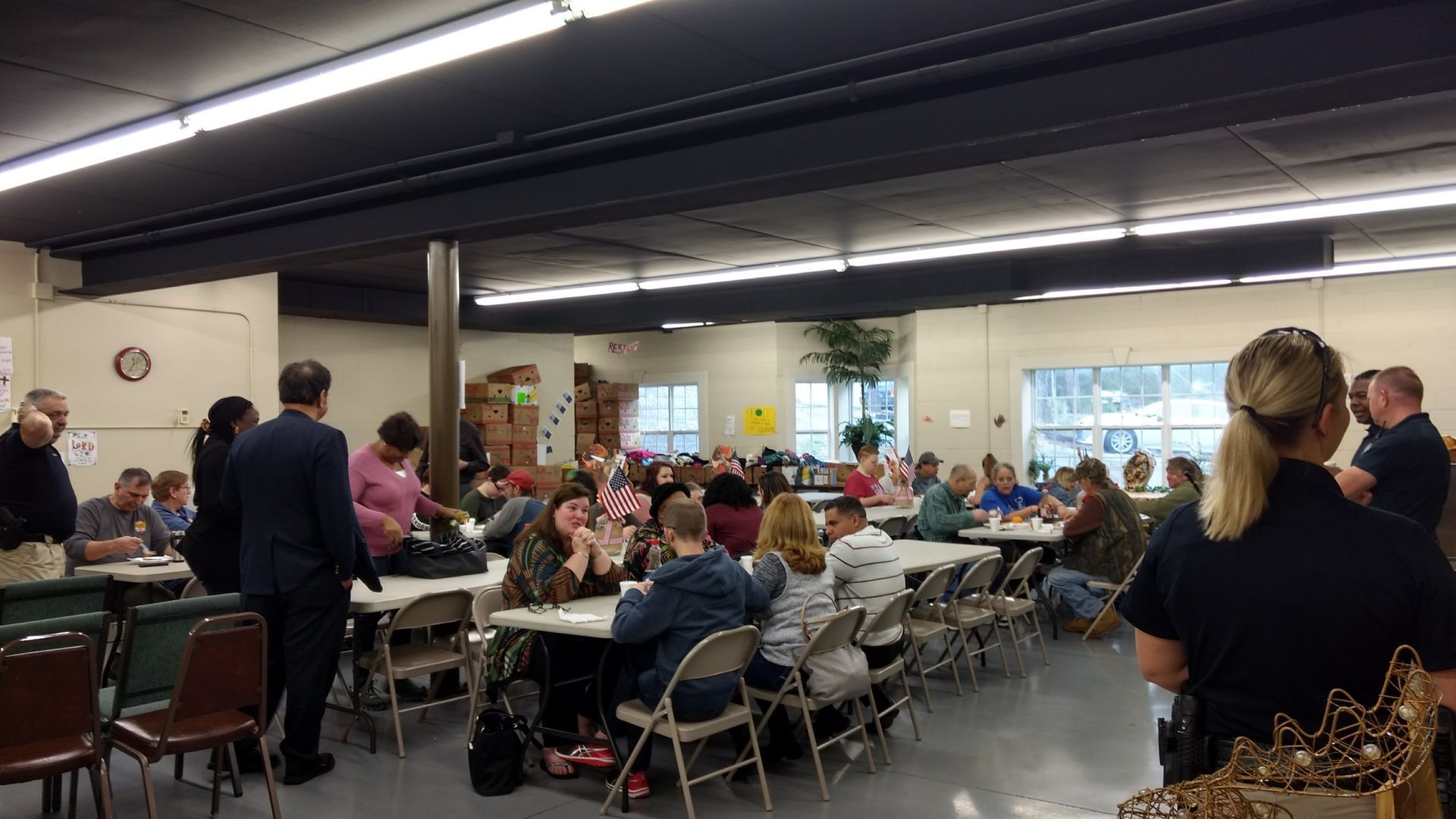 A group of people are sitting at tables in a large room.