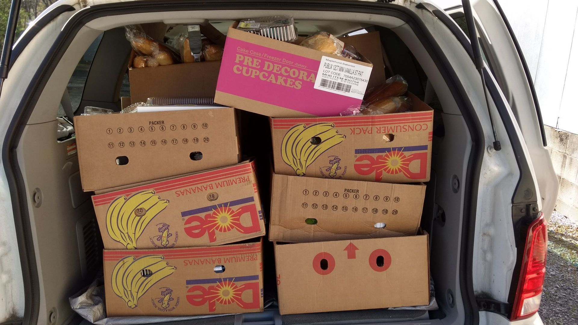 A stack of dole banana boxes in the back of a van