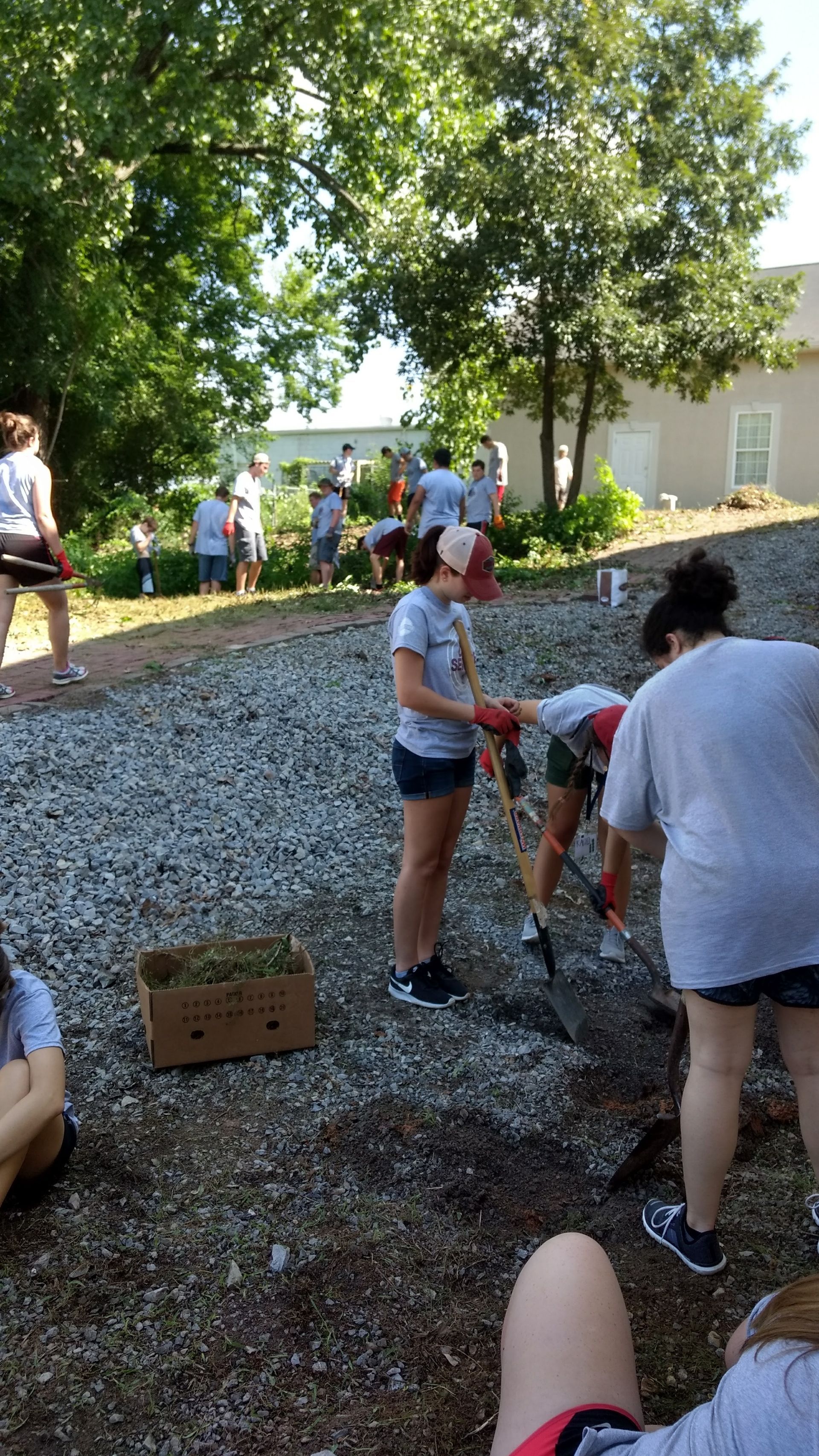 A group of people are working in a gravel yard.