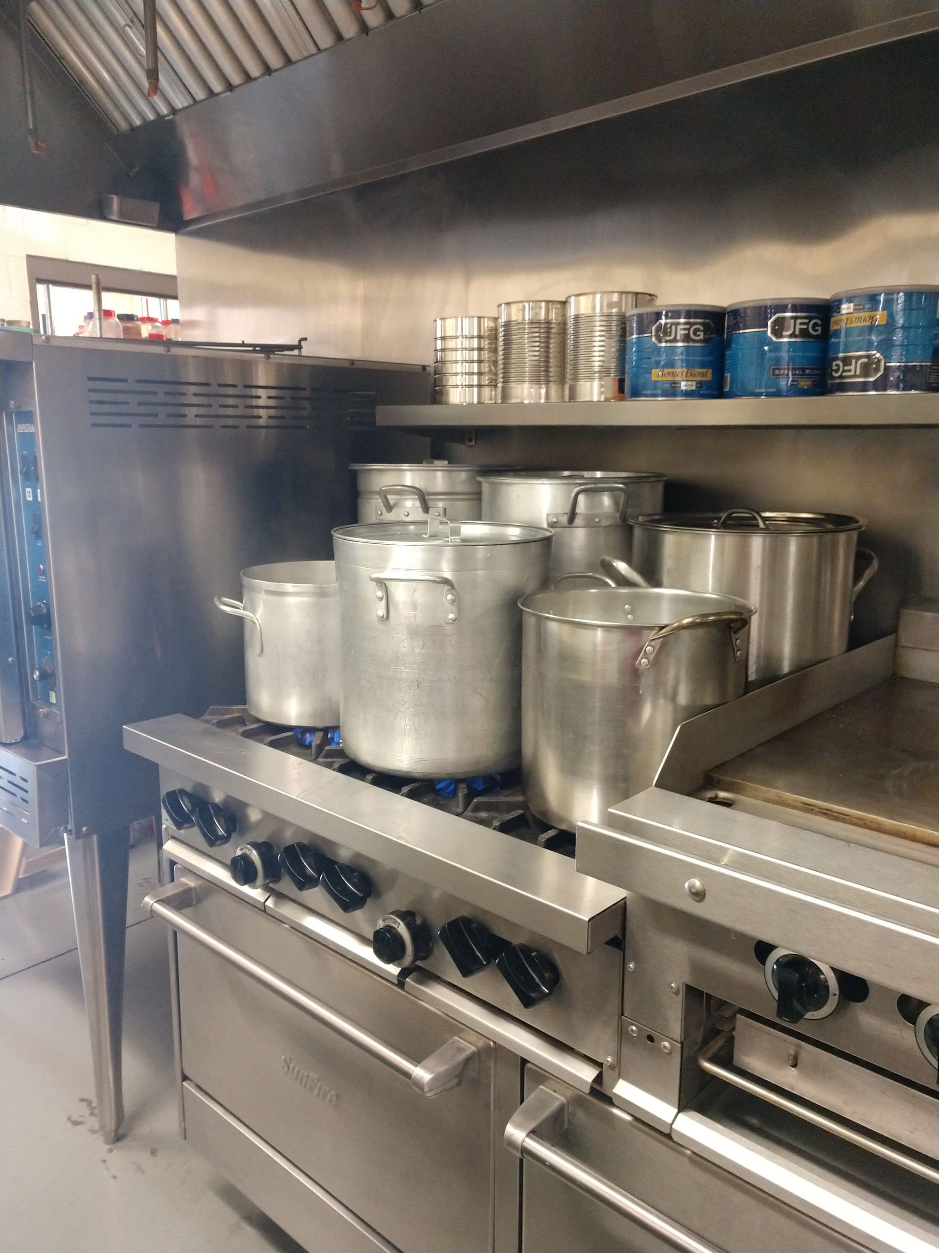 A kitchen with a lot of pots and pans on the stove