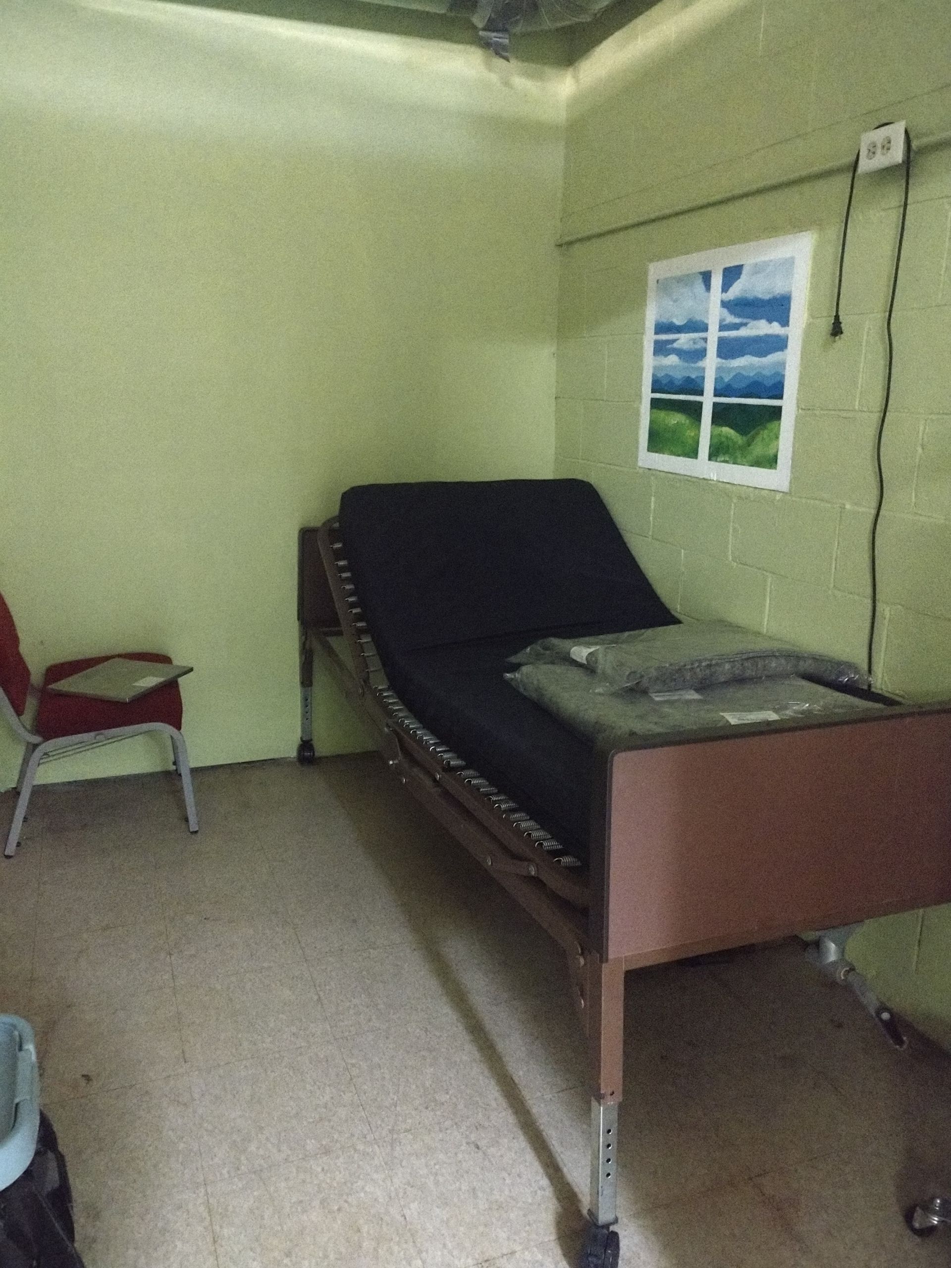 A hospital room with a bed and a chair