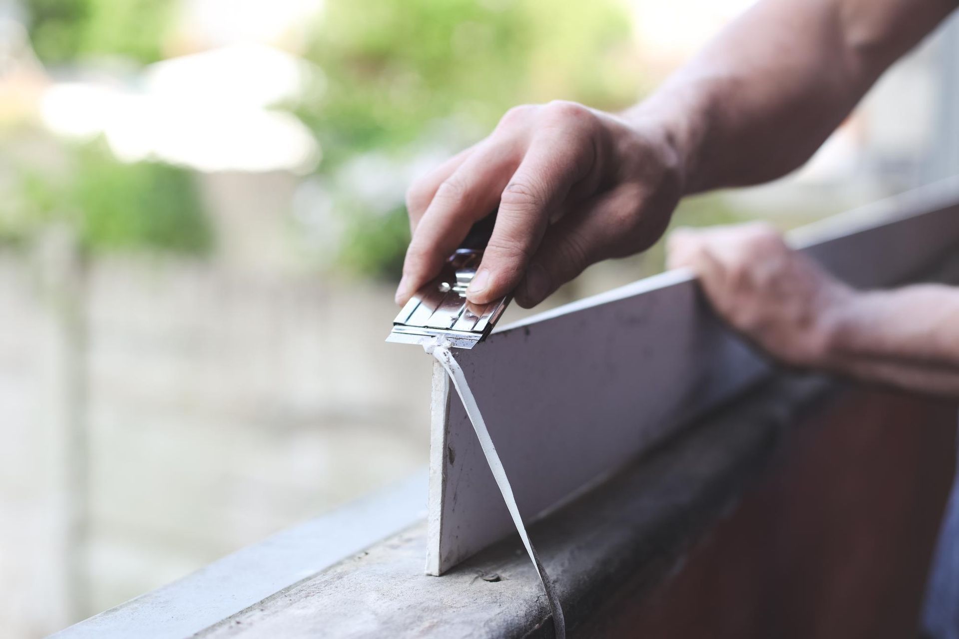 A person is cutting a piece of wood with a saw.