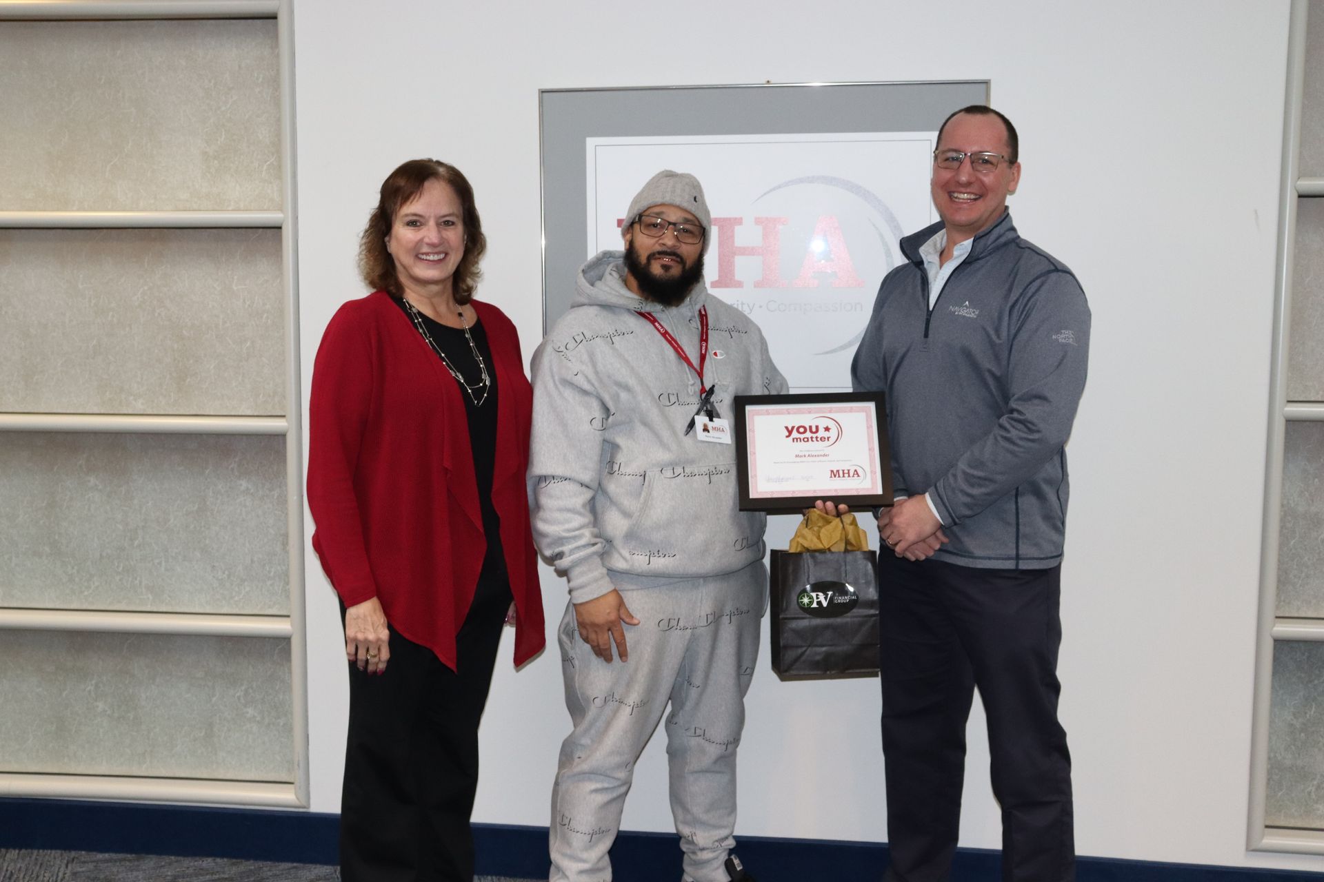 Mark Alexander poses with certificate next to Cheryl Fasano and member from Pioneer Valley Financial Group