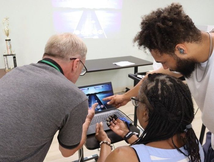 TRC staff teaching a member how to use MusicGlove.