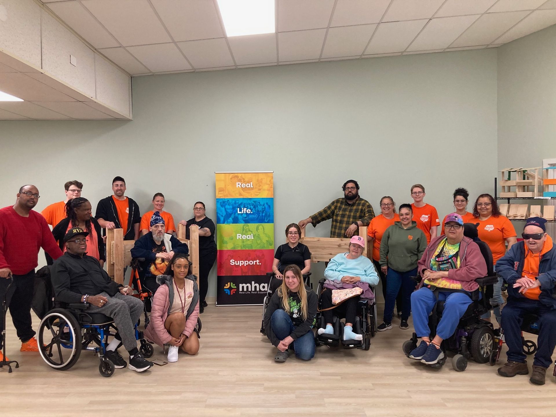 A group of people in wheelchairs are posing for a picture in a room.