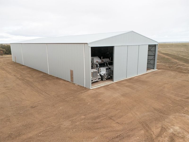 A large white building with a truck parked inside of it.