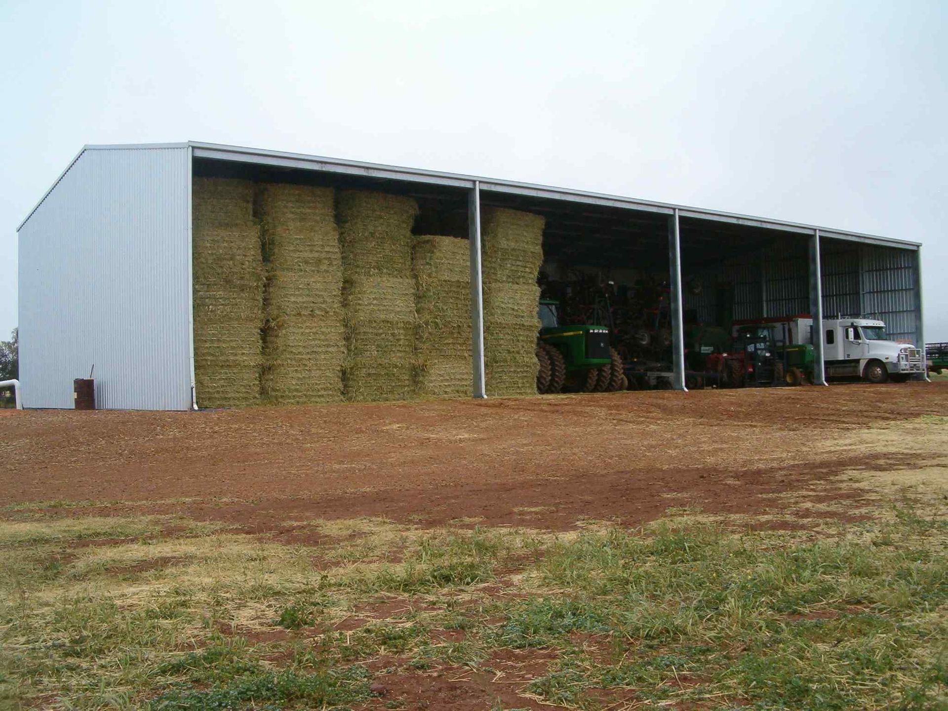 A large green metal building with a white door