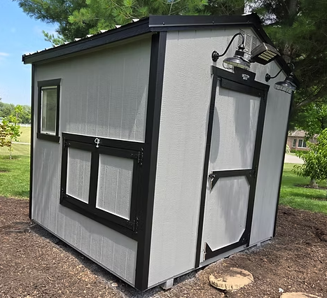 A white and black shed with a window and the number 9 on it