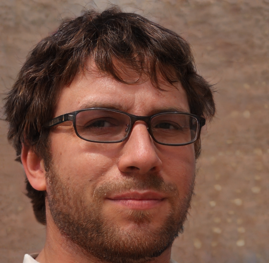 A man with glasses and a beard is smiling for the camera