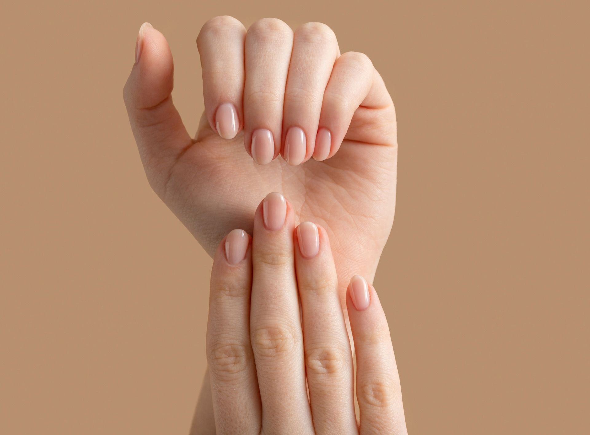 A close up of a woman 's hands on a brown background.