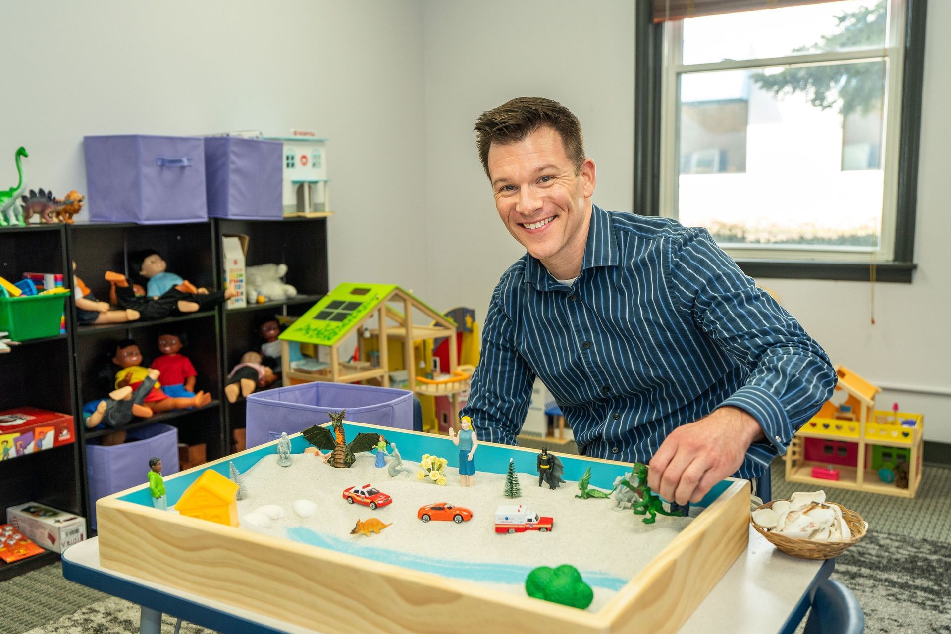 A young boy is playing with wooden blocks in front of an abacus.