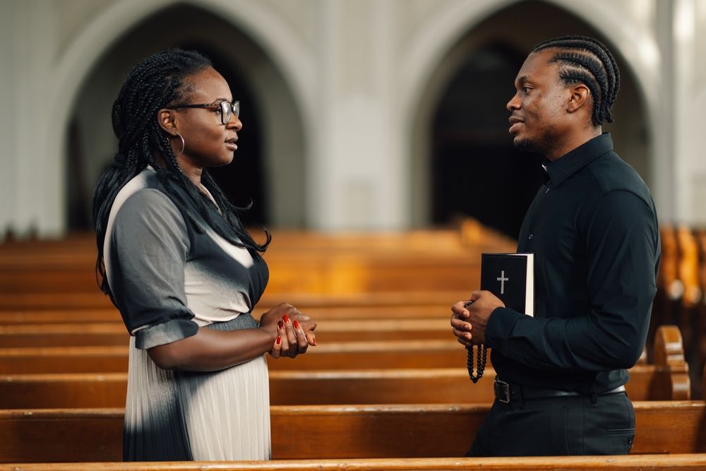 Two people are holding hands over a bible.