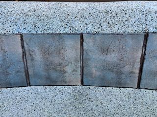 Blue tiled border with textured light blue stone on top and bottom.