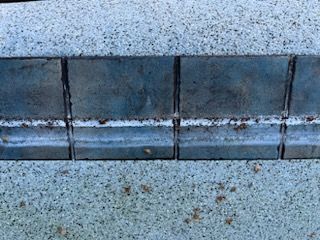 Blue tiles bordering textured light gray stone.