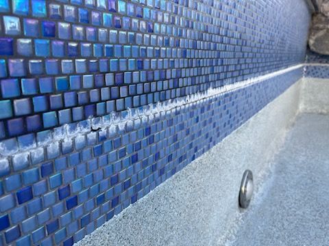 Blue tiled pool wall with white residue.