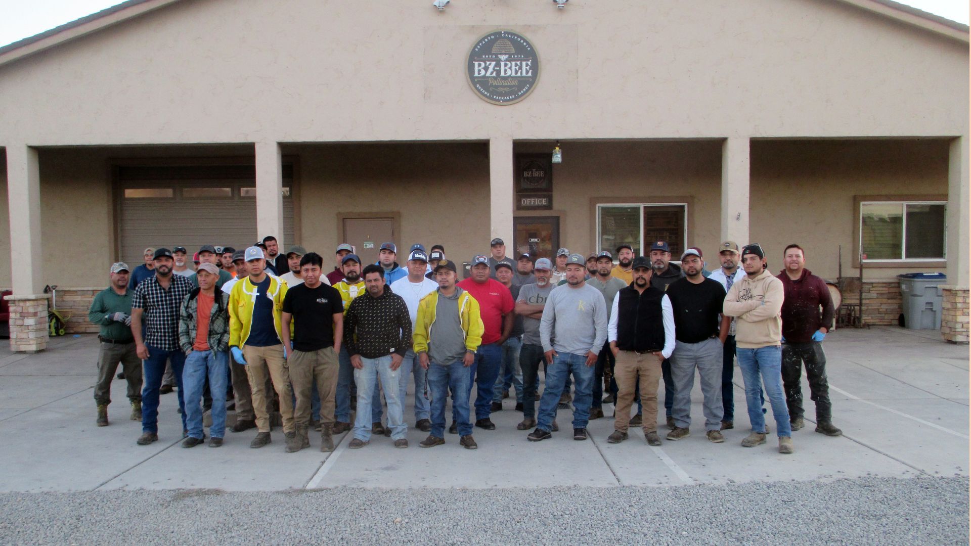 A group of diverse men stand in front of a building.
