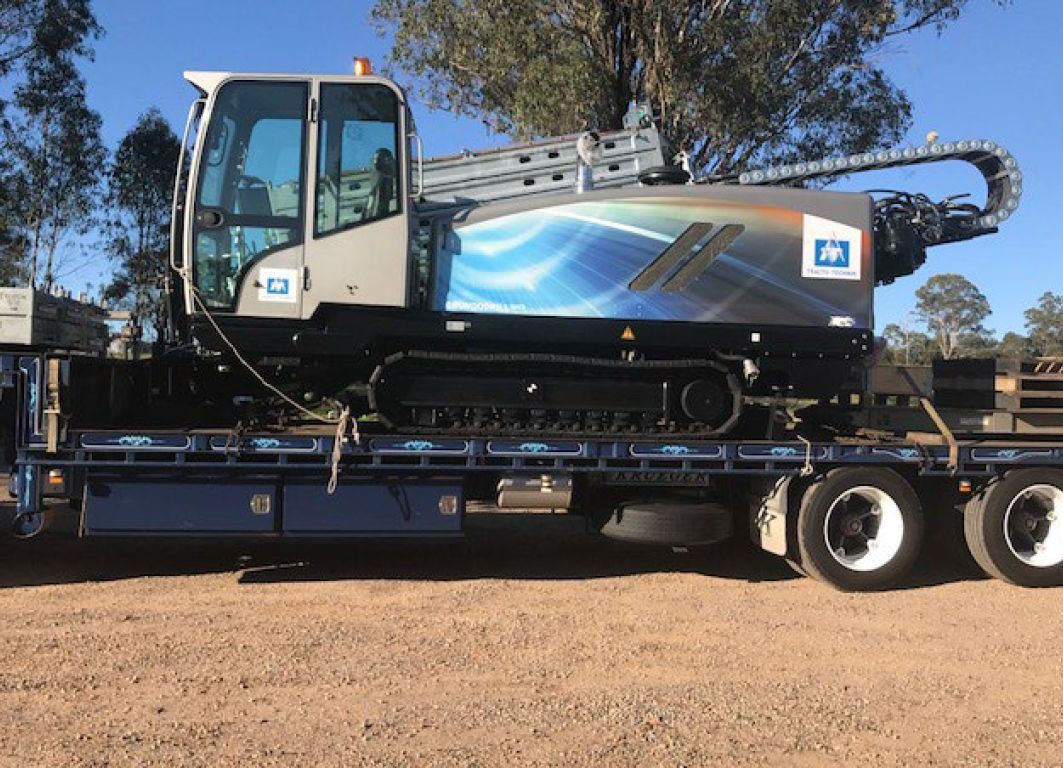 A large machine is sitting on top of a flatbed truck