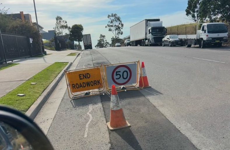 A road with a sign that says ' end roadwork ' on it