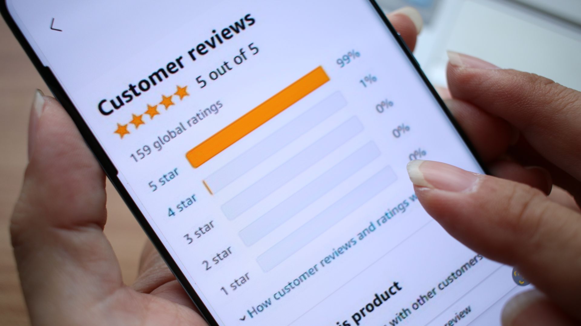 A person is holding a cell phone with a customer reviews page on it