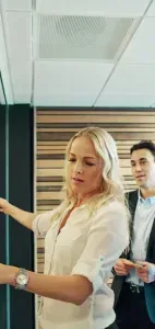 Team reviewing colorful sticky notes on a glass board in a modern office