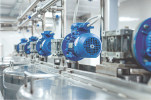 Row of blue industrial motors attached to equipment in a factory setting.