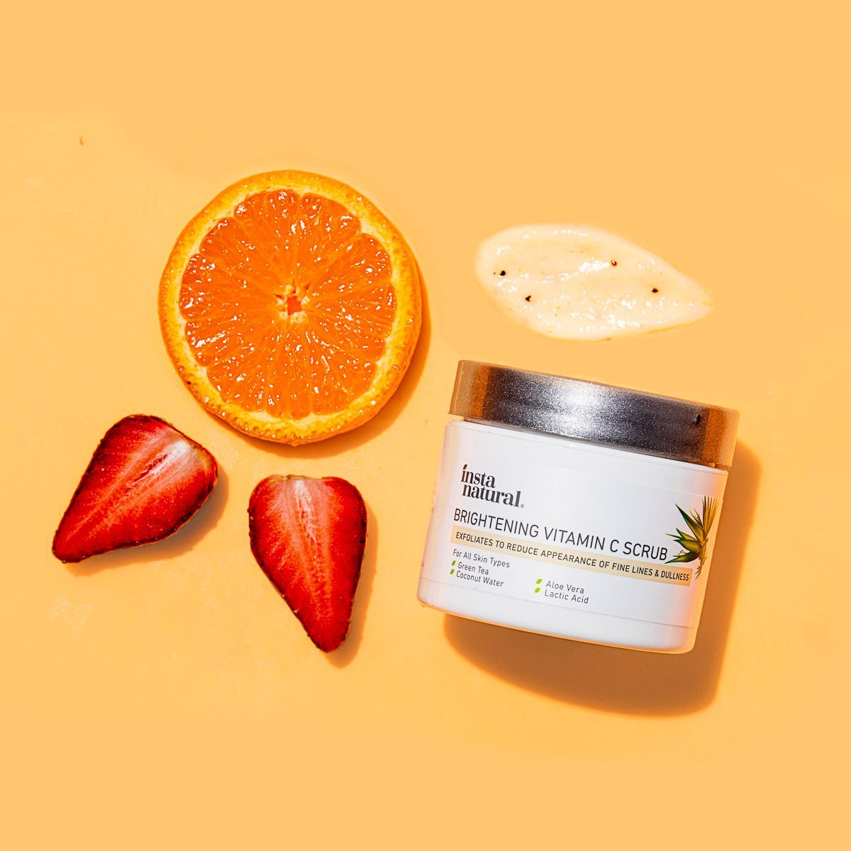 Instanatural skincare beauty product on orange paper with fresh orange + strawberry. By JAM Creative, product photographers.