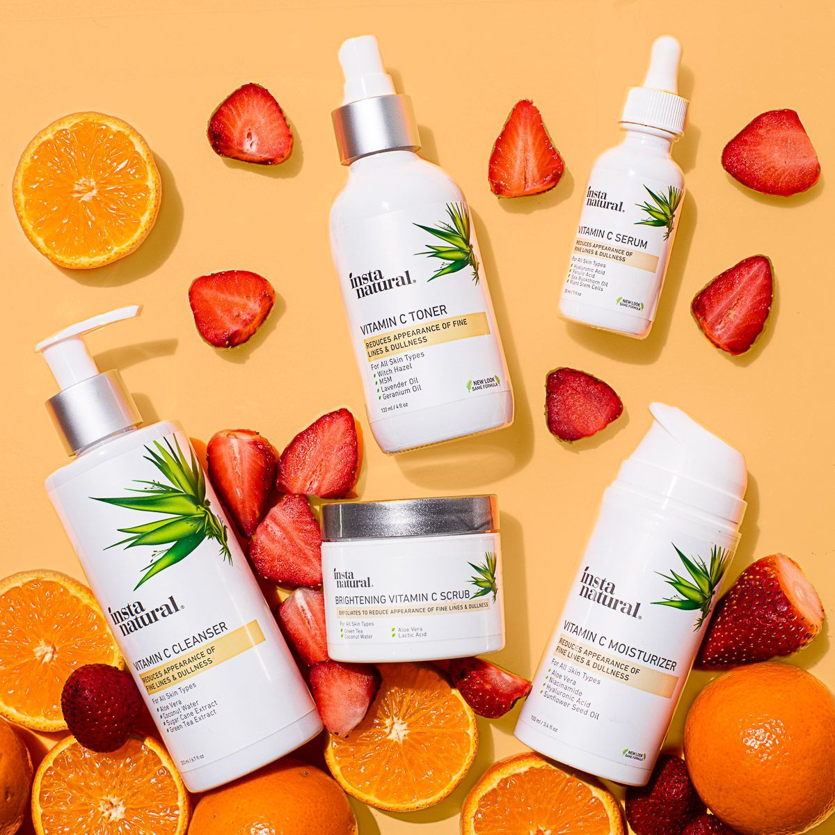 Instanatural skincare beauty products on orange paper with fresh orange + strawberry. By JAM Creative, product photographers.