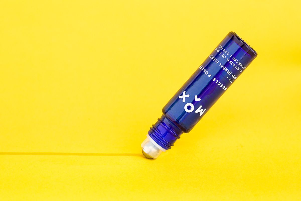 Mox skincare beauty roller product at an angle on yellow paper, drawing a line. By product photographers at JAM Creative.