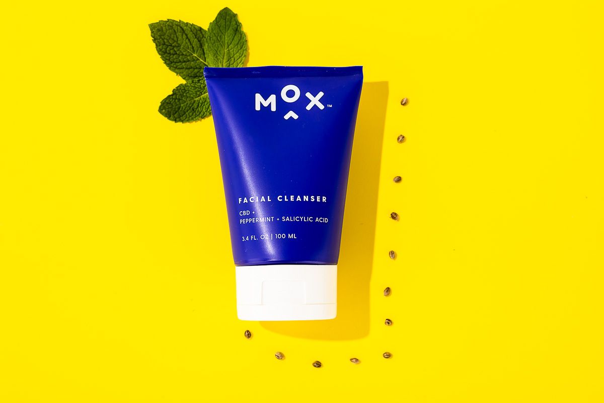 Mox skincare beauty product on yellow paper with fresh mint. By commercial product photographers at JAM Creative.