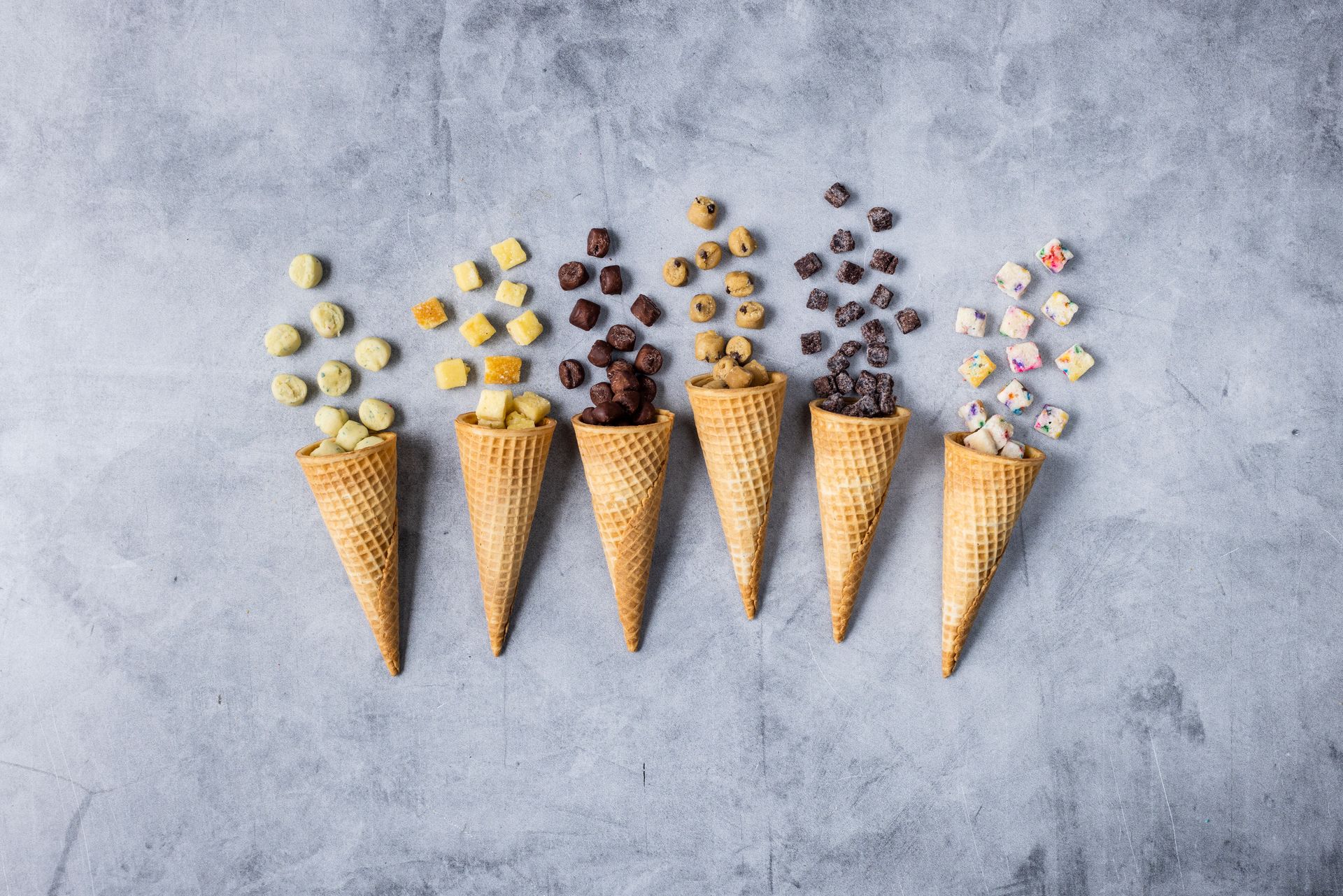 Brownie, chocolate chip cookie and other ice cream inclusions cascade out of cones by JAM Creative for Rhino Foods.
