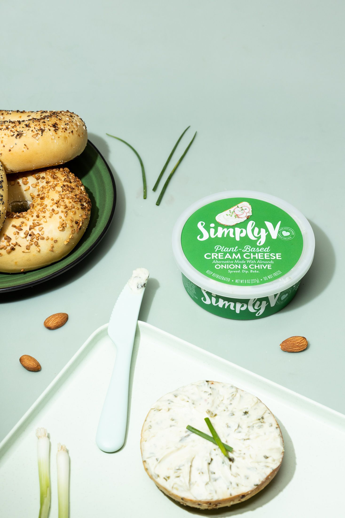 Lifestyle product food photography of Simply V onion + chive cream cheese on green. By JAM Creative commercial photography.