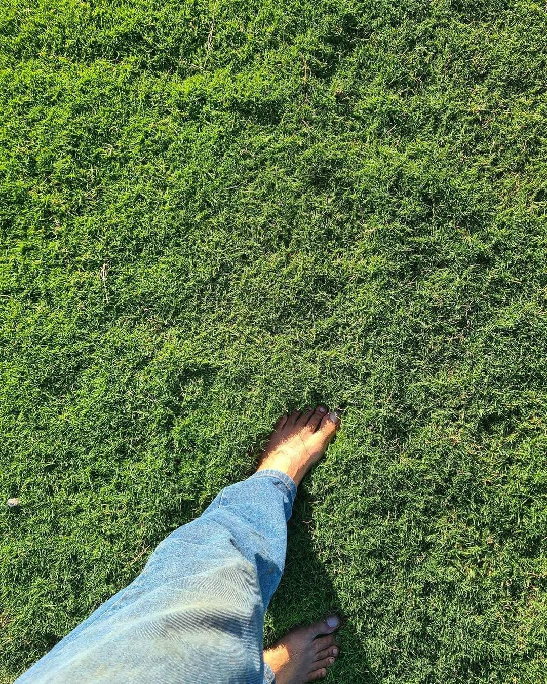 Bare Feet and Denim-Clad Leg on Lush Green Grass, Walking Outdoors — Top Notch Turf in Winton, QLD
