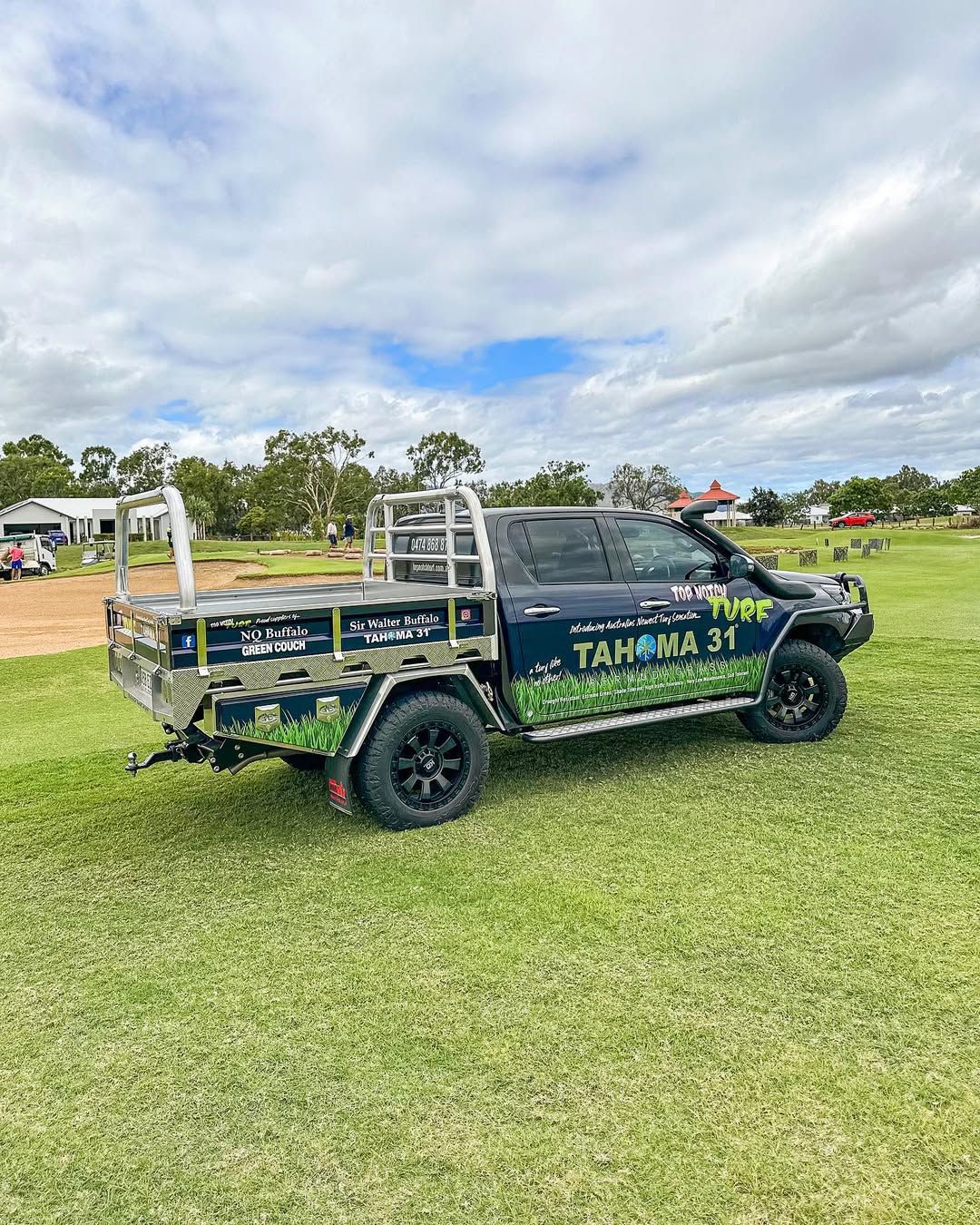 Black Pickup Truck with Landscaping Business Graphics on Grass Field — Top Notch Turf in Mount Isa, QLD