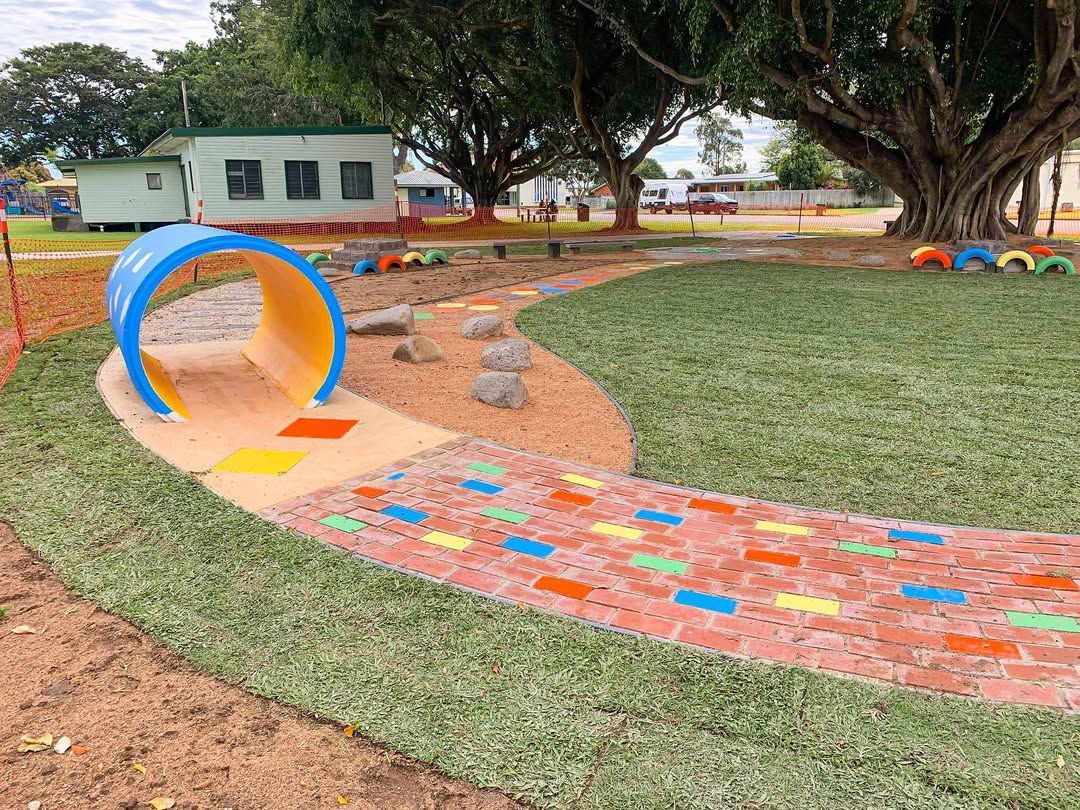 Playground with Blue Tunnel, Colorful Pathway, Rocks, and Grass — Top Notch Turf in Clermont, QLD