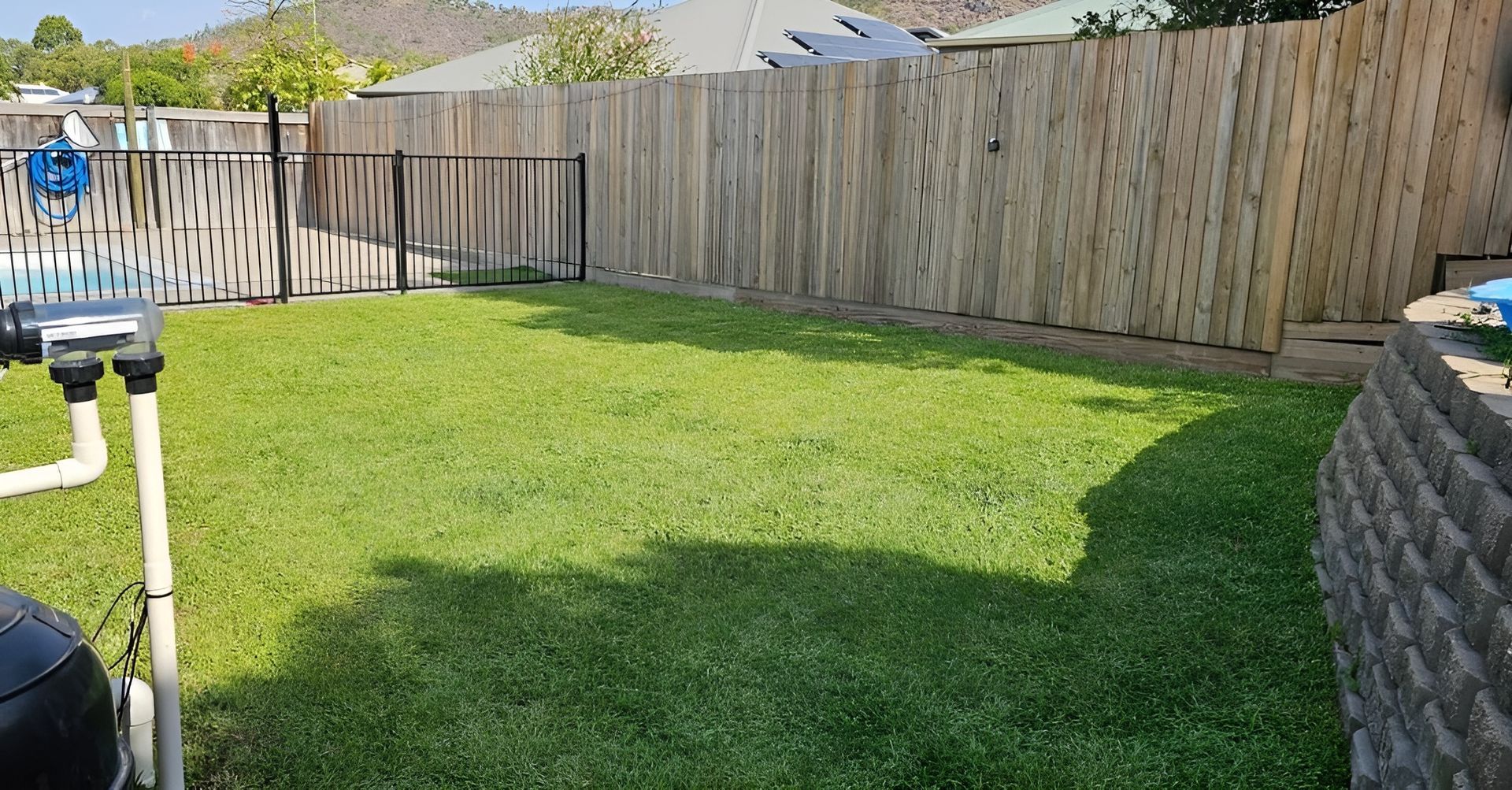 Backyard with Green Grass, Various Fences, and A Pool Equipment — Top Notch Turf in Ingham, QLD