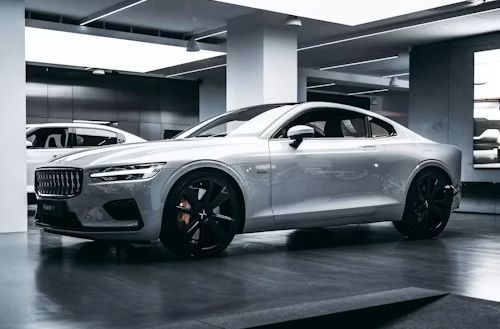 Silver sports coupe parked in a modern garage with black rims and sleek low-profile design
