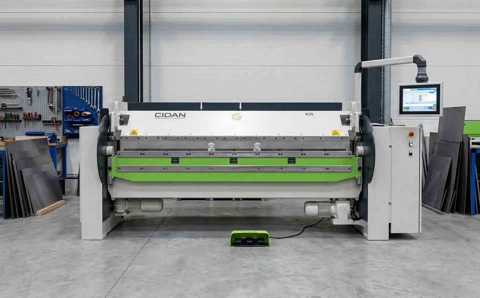 Une machine moderne de pliage de tôles industrielles dans un atelier, équipée d'un rouleau de pliage vert et d'un écran de contrôle.