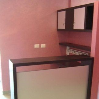 Realizzazione mobile reception per studio dentistico in rovere tinta venghè, particolare fronte.