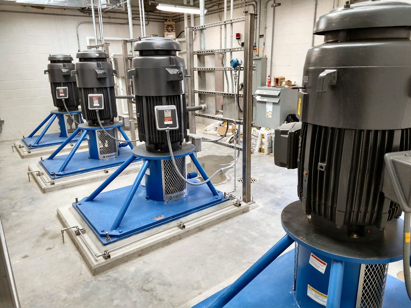 A row of electric motors are sitting on top of each other in a room.