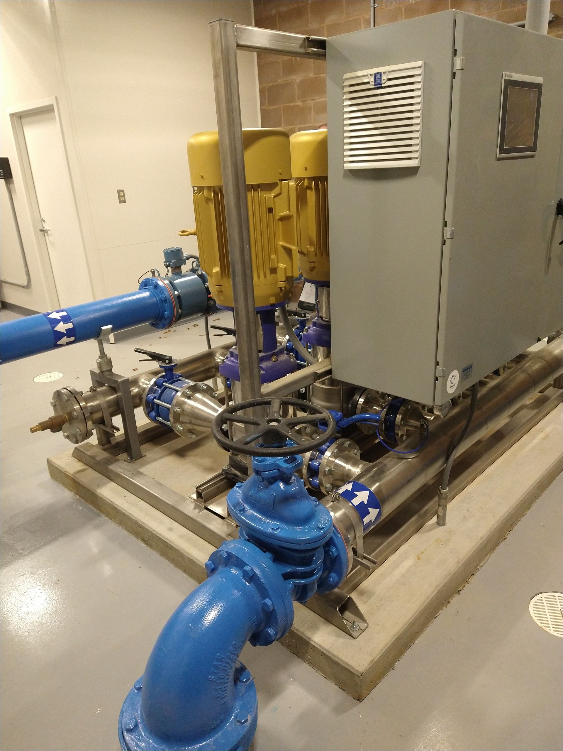 A bunch of blue pipes are connected to a machine in a room.