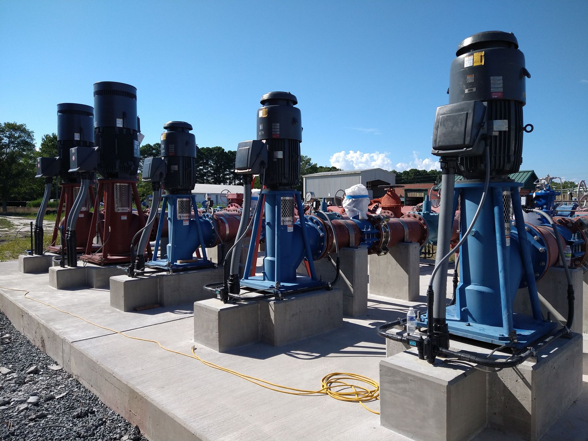 A row of blue pumps are lined up on concrete blocks